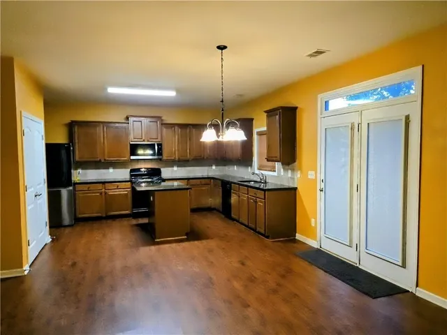 a kitchen with kitchen island a sink stainless steel appliances and cabinets