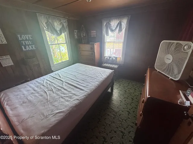 a room with a bed and windows