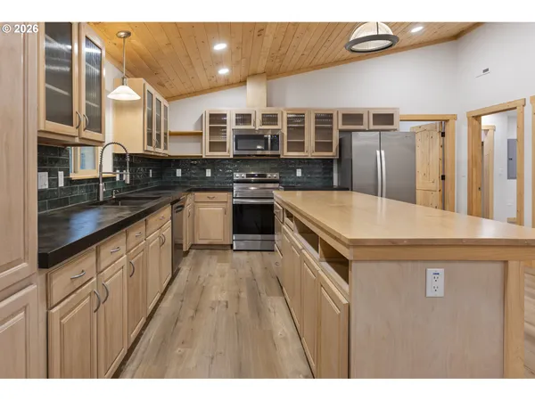 a kitchen with stainless steel appliances granite countertop a stove a sink and a refrigerator