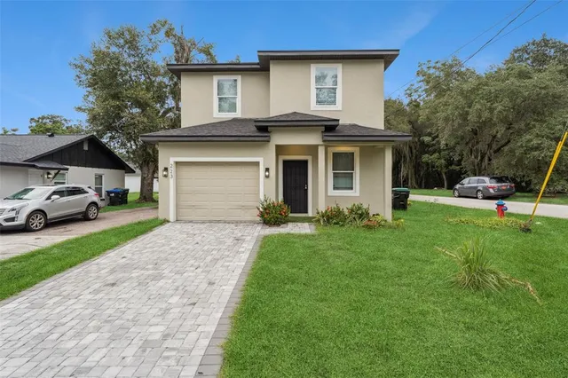a front view of a house with a garden and trees
