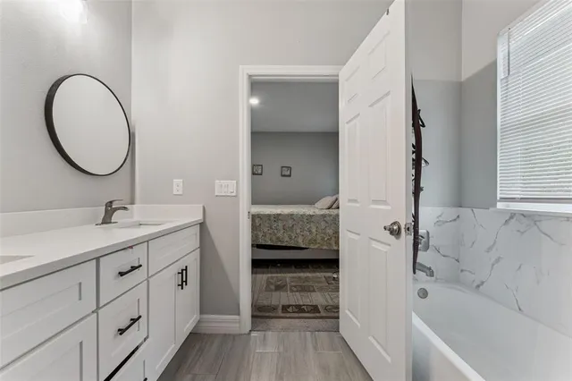 a bathroom with a tub sink and mirror