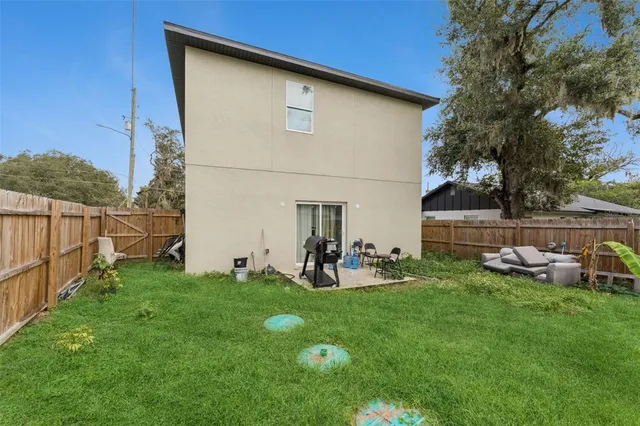 a view of backyard with chairs and wooden fence