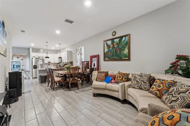 a living room with furniture and a dining table with kitchen view