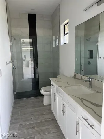 a bathroom with a granite countertop sink toilet and shower