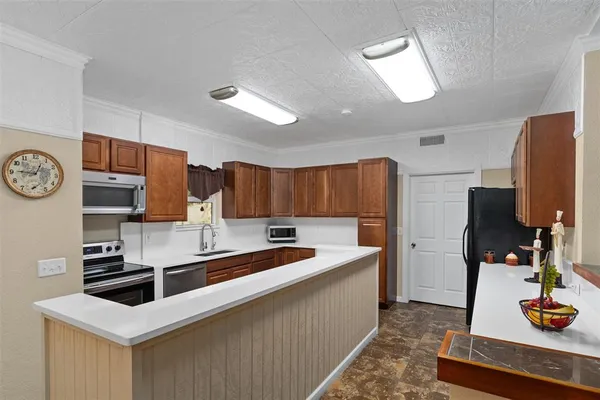 a kitchen with stainless steel appliances granite countertop a sink a stove and a refrigerator