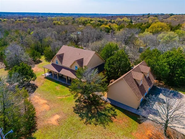 an aerial view of a house with a garden and swimming pool
