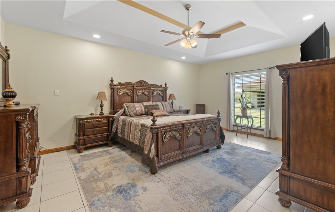 5763 Santa Isabelle Drive Robstown, TX 78380 - Photo 14 of 26 a spacious bedroom with a bed a window and a flat screen tv