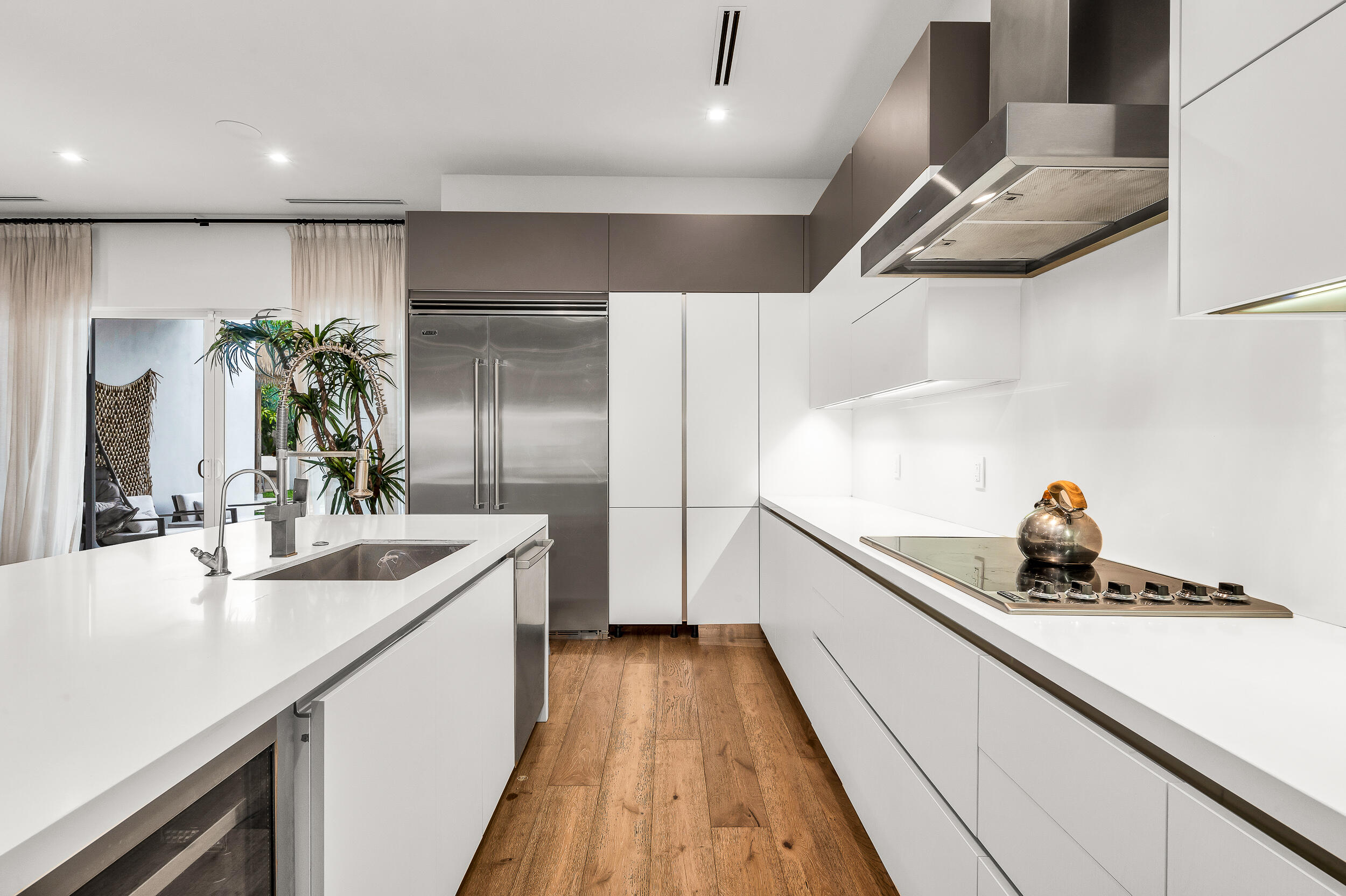 4740 Bay Point Road Miami, FL 33137 - Photo 6 of 27 a kitchen with kitchen island a counter top space a sink a refrigerator and wooden floor