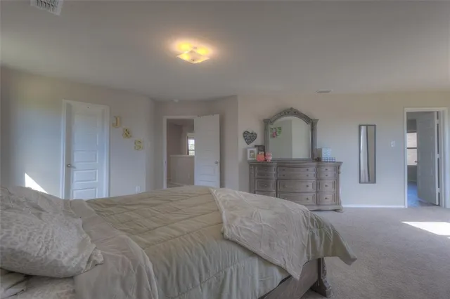 a bedroom with a bed and a view of en suite bathroom