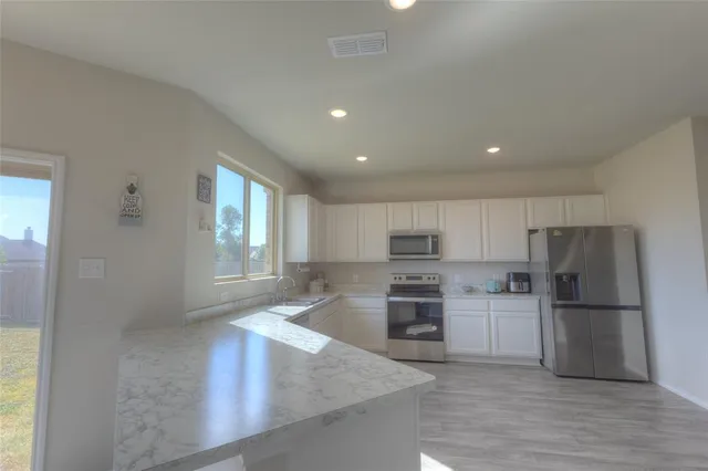 a kitchen with refrigerator and cabinets