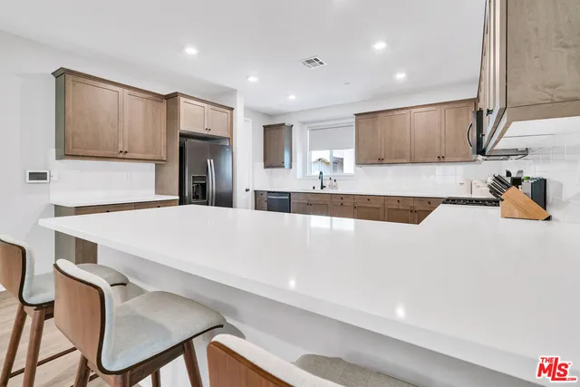a large white kitchen with a large counter top appliances and cabinets