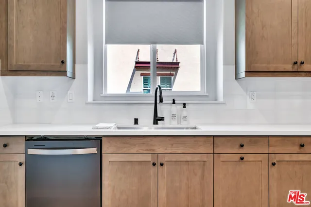 a kitchen with a sink cabinets and a window