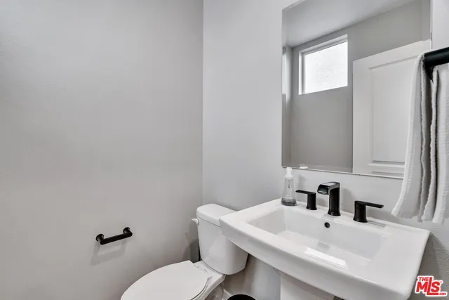 a bathroom with a sink mirror and toilet