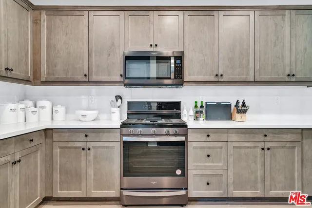 a kitchen with granite countertop white cabinets and stainless steel appliances