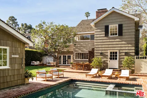 a front view of a house with swimming pool and sitting area