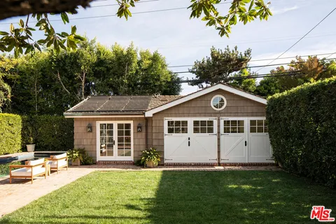a view of a house with a yard and potted plants