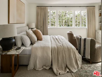 a bedroom with a bed and large window