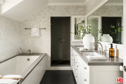 a bathroom with a bathtub sink and mirror