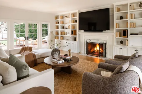 a living room with furniture a flat screen tv and a fireplace