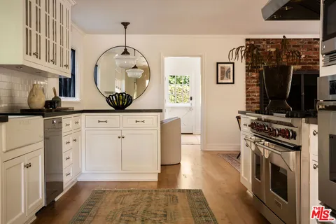 a kitchen with white cabinets and black appliances