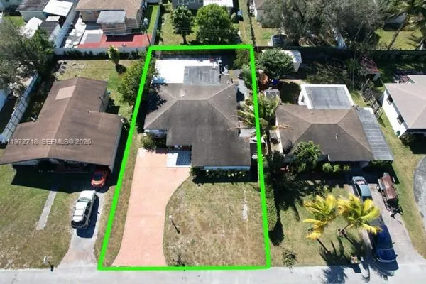 an aerial view of a house with a yard and large trees