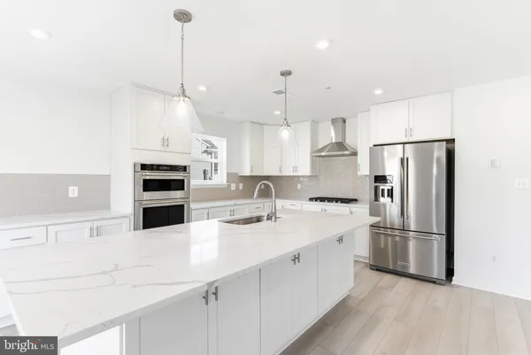a kitchen with stainless steel appliances kitchen island a refrigerator sink and cabinets