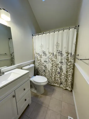 a bathroom with a granite countertop toilet and a sink