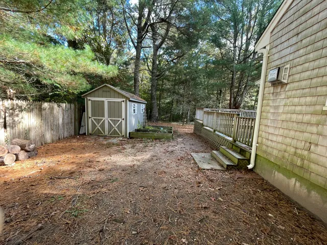 a view of a house with a yard and large trees