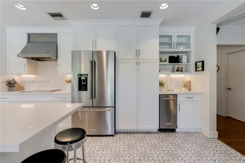 a kitchen with stainless steel appliances granite countertop a refrigerator sink and stove