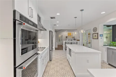 a large white kitchen with stainless steel appliances