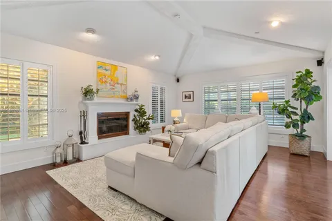 a living room with furniture large window and a fireplace