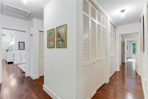 a large white bed sitting in a bedroom next to a window with a chandelier