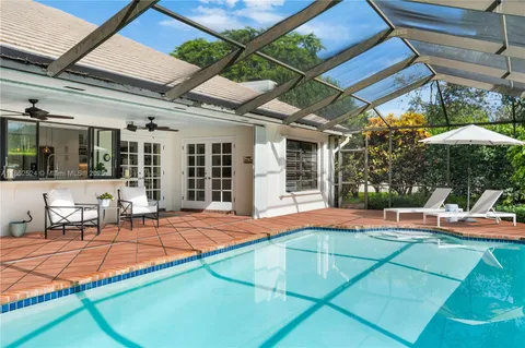a view of a house with a big yard and palm trees