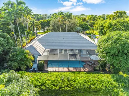 a front view of a house with a garden and trees
