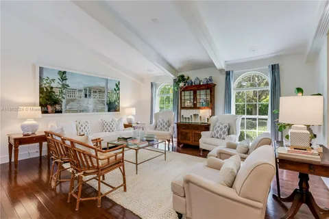 a living room with furniture a flat screen tv and a large window