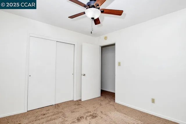 a view of a hallway with a ceiling fan