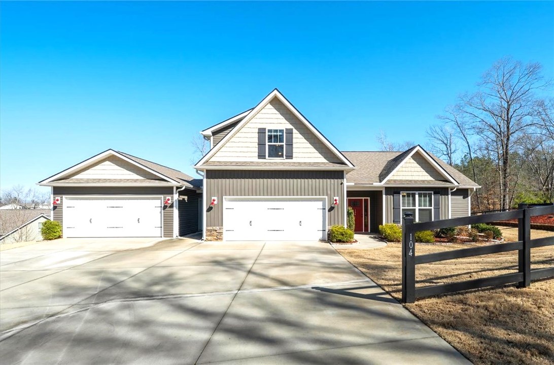 104 Inlet Pointe Drive Anderson, SC 29625 - Photo 1 of 50 This appealing dwelling offers a concrete driveway and two convenient garages, all beneath a vibrant blue sky.