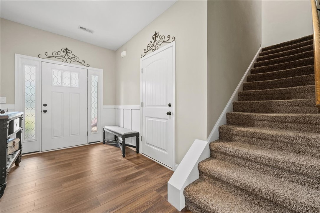 104 Inlet Pointe Drive Anderson, SC 29625 - Photo 6 of 50 This inviting entryway features warm wood flooring and a classic staircase, offering a welcoming first impression.