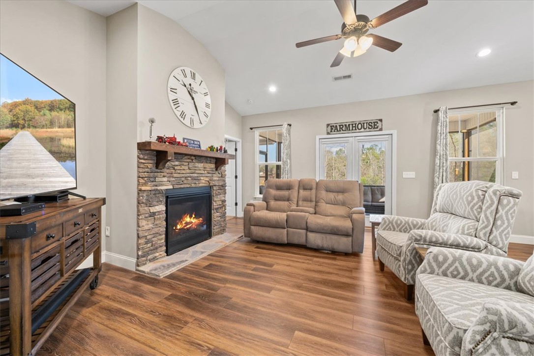 104 Inlet Pointe Drive Anderson, SC 29625 - Photo 10 of 50 This living area features a warm fireplace, rich flooring, and a luminous window.