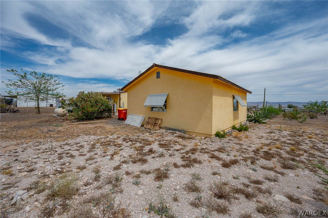 2465 Egar Road Golden Valley, AZ 86413 - Photo 48 of 98 The property features a single-story structure with a yellow exterior and a brown roof
