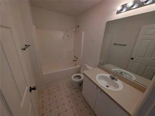 en empty room with windows and ceiling fan