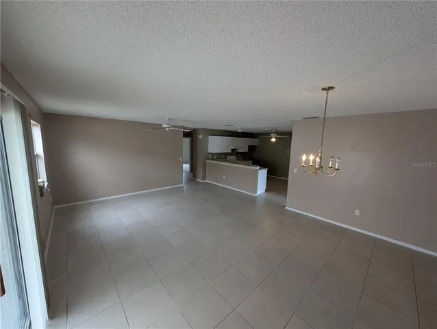 a large white kitchen with a sink a window and stainless steel appliances