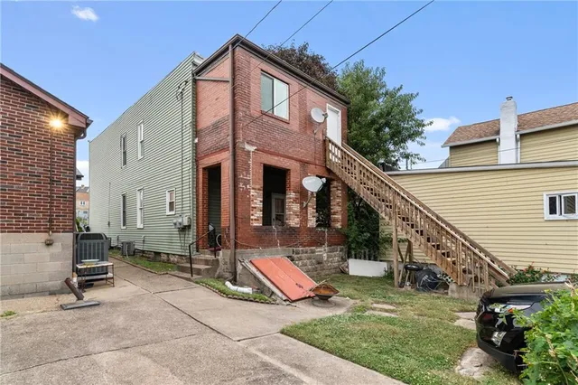 front view of building with a yard and staircase