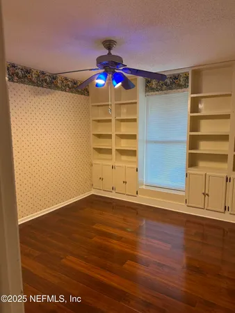 a view of a room with wooden floor and white walls