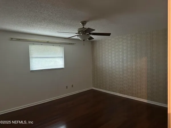 a view of a small space with wooden floor fan and windows