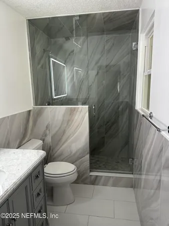 a bathroom with a toilet and a shower