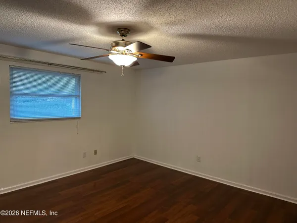 a view of a room with wooden floor closet and chandelier fan