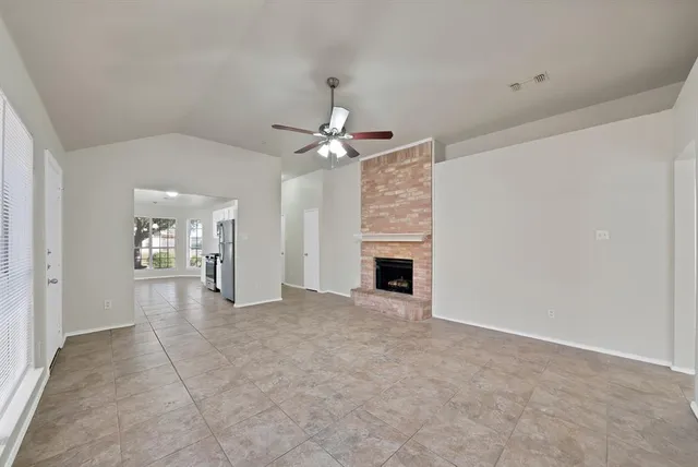 an empty room with fireplace and fan