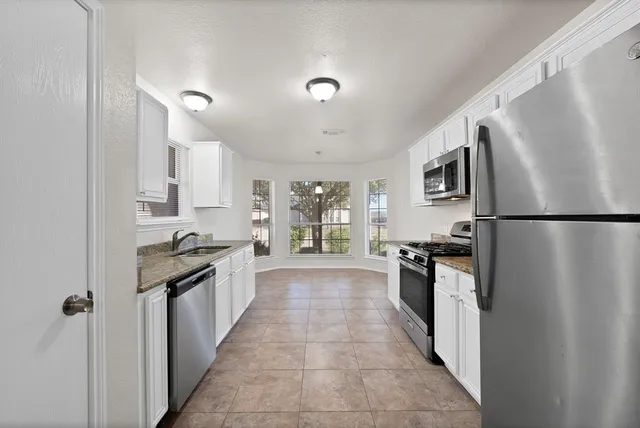 a large kitchen with a stove a refrigerator and a sink