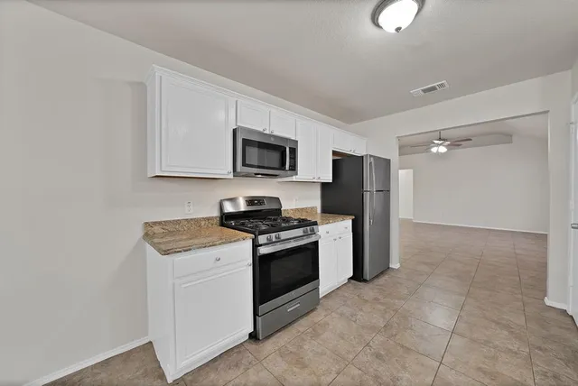a kitchen with a stove a refrigerator and a sink